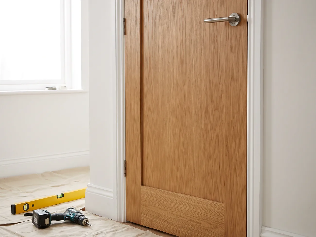 Placeholder image: a newly fitted oak internal door with painted skirting and architrave.